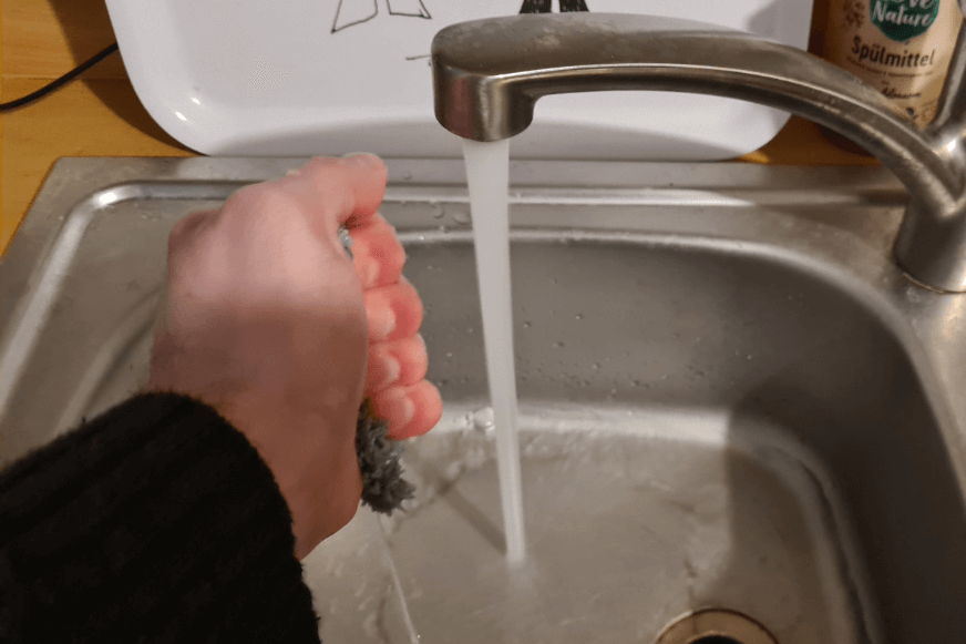 Die Wischmopps des Dreame L10s Pro werden ausgewrungen, nachdem sie unter fließendem Wasser angefeuchtet wurden.